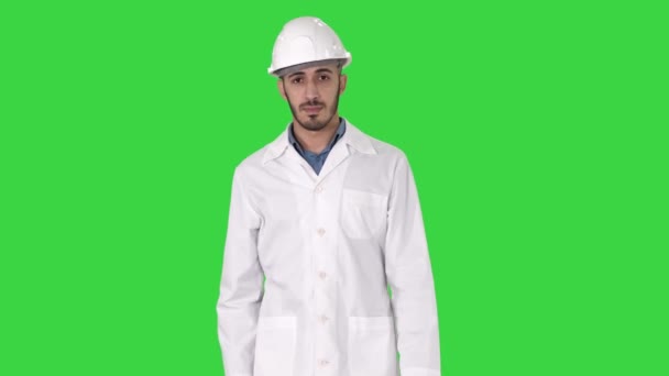 Άραβας μηχανικός σε κράνος και λευκό μανδύα περπατώντας προς τα εμπρός σε μια πράσινη οθόνη, πλήκτρο αποχρώσεων. — Αρχείο Βίντεο