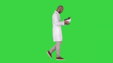 Bilim mühendisi yürüyüş ve yeşil ekran, Chroma anahtar güvenlik konsepti üzerinde kask koyarak.