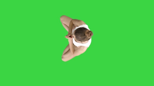 Junge kaukasische blonde Frau praktiziert Yoga auf einem grünen Bildschirm, chroma key. — Stockvideo
