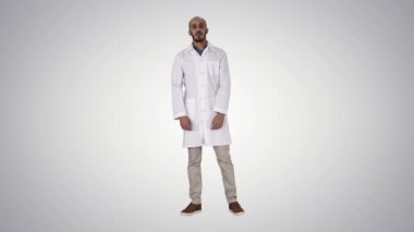 Doktor adam biraz gergin ve degrade arka planda ayakta korkuyor.