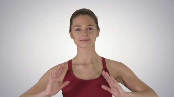 Jonge vrouw doet yoga ademhalingsoefeningen op gradiënt achtergrond. — Stockvideo