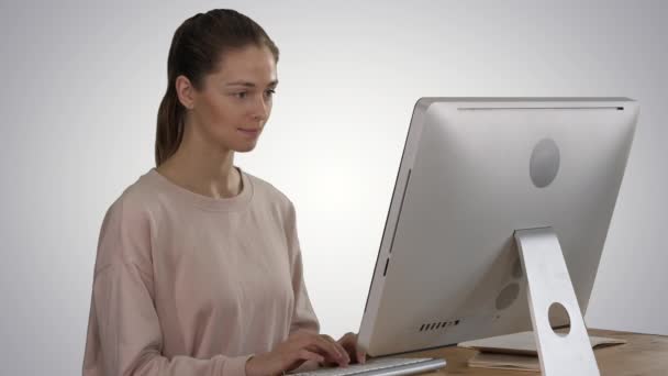 Femme pigiste travaille sur un nouveau projet sur ordinateur sur fond de gradient. — Video