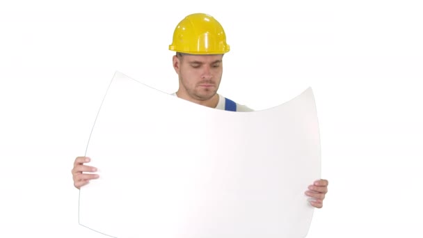 Задумчивый строитель в шлеме смотрит на чертеж и ходит на белом фоне. — стоковое видео