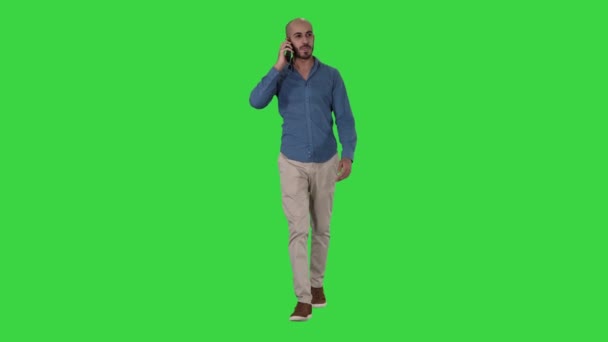 Jonge Arabische man lopen en praten over de telefoon en glimlach op een groen scherm, Chroma Key. — Stockvideo