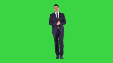 İş adamı yürüyor ve kameraya Yeşil Ekran, Chroma Key 'de bir şey anlatıyor..