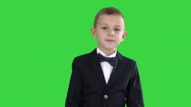 Yeşil Ekranda yürüyen papyonlu kostümlü küçük çocuk, Chroma Key.