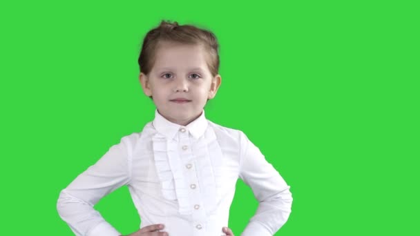 Χαριτωμένο κοριτσάκι με λευκό φόρεμα που ποζάρει στην κάμερα σε μια πράσινη οθόνη, πλήκτρο αποχρώσεων. — Αρχείο Βίντεο