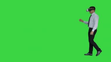 Yeşil Ekranda VR kulaklığı kullanan genç işadamı, Chroma Key.
