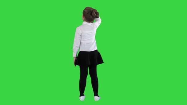 Μικρό κορίτσι που κοιτάζει μακριά σε μια πράσινη οθόνη, πλήκτρο αποχρώσεων. — Αρχείο Βίντεο