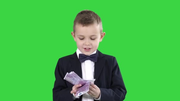 Little boy in a suit counting money on a Green Screen, Chroma Key. — Stock Video