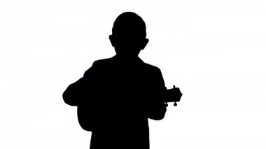Siluet Boy bir kostüm yürüyüş ve ukulele oynarken.