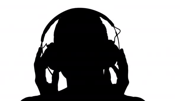 Silhouette Charming nő mosolyog, miközben zenét hallgat a fülhallgatóban. — Stock videók