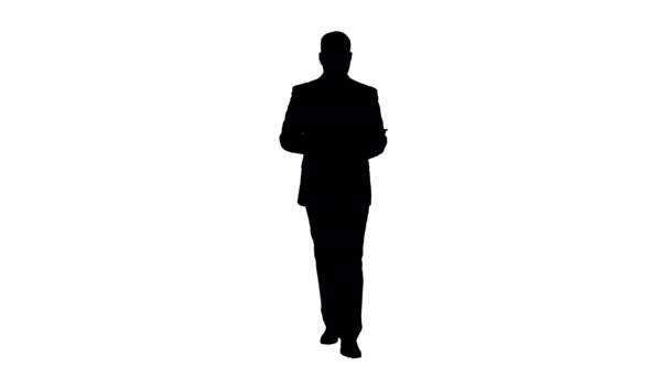 Silhouette Businessman camminando e scorrendo pagine sul suo computer tablet e cercando di fotocamera che presenta qualcosa. — Video Stock