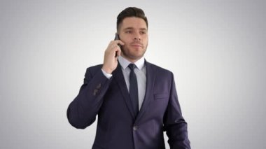 Ciddi endişeli işadamı degrade arka plan üzerinde cep telefonu konuşuyor.
