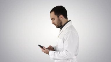 Yakışıklı erkek sağlık hizmetleri uzmanının, doktorun ya da hemşirenin yakın plan portresi. Grafiksel arka planda cep telefonuyla mesajlaşıyor..