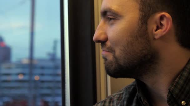Mladý muž přemýšlí a dívá se na okno ve vlaku. — Stock video