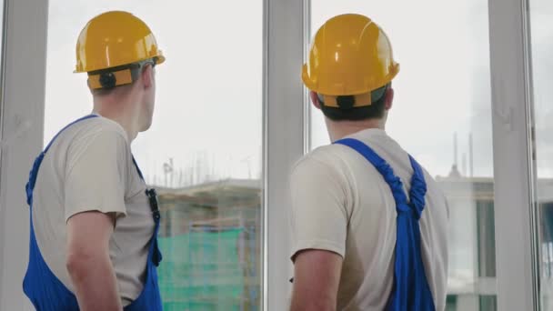 Superviseur montrant quelque chose à un collègue sur le chantier de construction. — Video