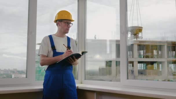 Stavební pracovník, který zapisuje kontrolní seznam nebo bere poznámky. — Stock video