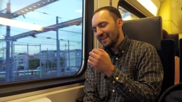 Vrolijke man die een grap vertelt en lacht in een trein. — Stockvideo