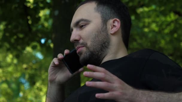 Красивый молодой мужчина разговаривает по мобильному телефону . — стоковое видео