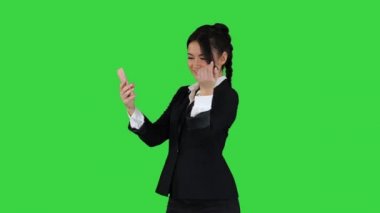 İş kadını akıllı telefonlara bakar ve yeşil ekranda dans eder, Chroma Key.