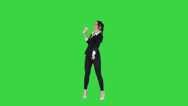 Mooie jonge zakenvrouw met een koffiepauze met take away koffie en dansen op een groen scherm, Chroma Key. — Stockvideo