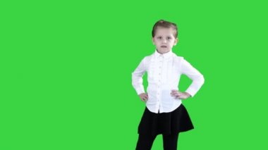 Beyaz küçük gülümseyen kız yeşil ekran üzerinde pozlar, chroma key.