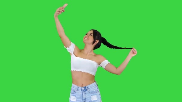 Jolie fille brune prend un selfie et danse sur un écran vert, Chroma Key. — Video