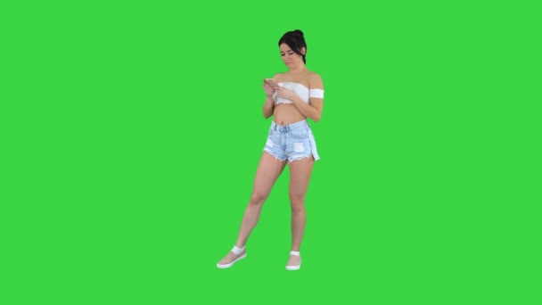 Positivepretty ragazza sexy ascoltare musica sul suo telefono su uno schermo verde, Chroma Key. — Video Stock