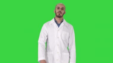 Yeşil Ekranda kameraya bakarak dolaşan ve konuşan dost canlısı erkek doktor, Chroma Key.