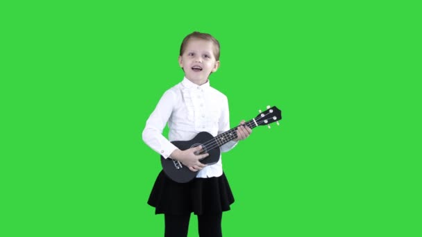 Vrij emotioneel jong meisje zingen met ukulele op een groen scherm, Chroma Key. — Stockvideo