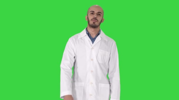 Freundlicher männlicher Arzt, der in die Kamera auf einen grünen Bildschirm schaut, Chroma-Schlüssel. — Stockvideo