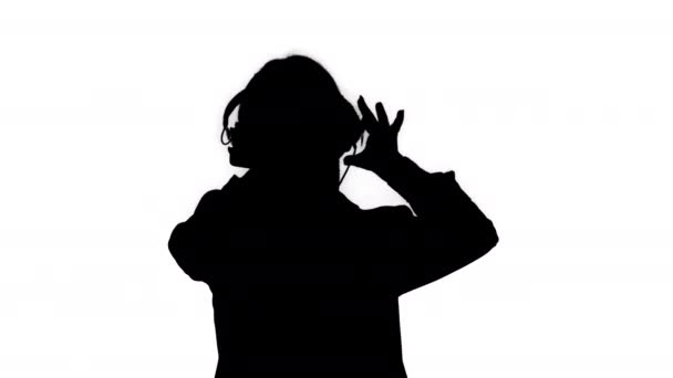 Silhouette Giovane donna d'affari che ascolta musica in cuffia e danza . — Video Stock