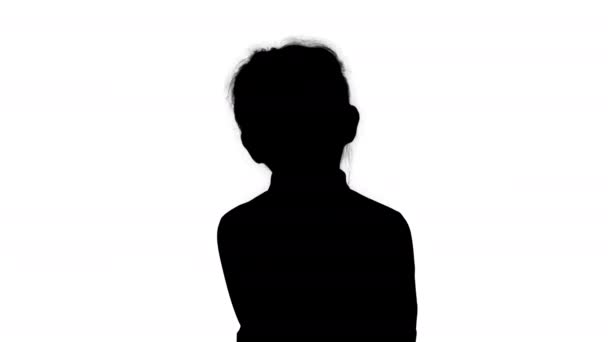 Silhouette Une curieuse petite fille se tient debout et pense . — Video