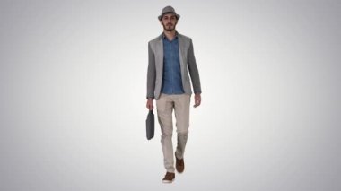 Casual Arap adam bir şapka yürüyüş ve degrade arka planda bir evrak çantası ile.