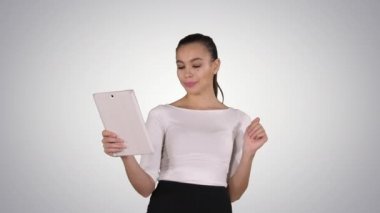Mutlu kadın tablet degrade arka plan üzerinde video seslenmek yolu ile sohbet.