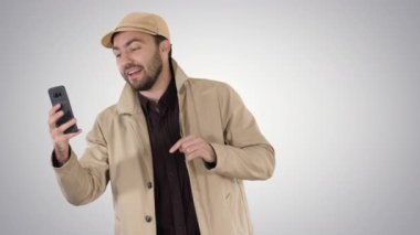 Gradyan arkaplanda yürürken telefonuna video kaydeden bir blogcu.