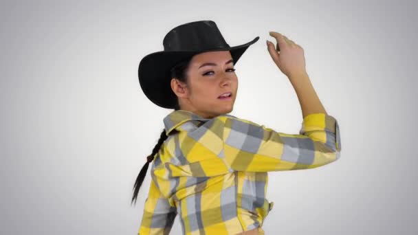 Young cowgirl dancing on gradient background. — Stock Video