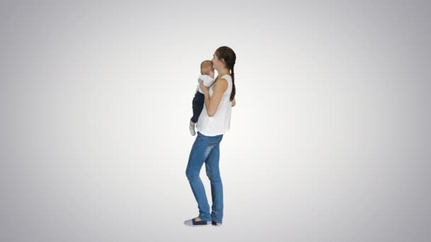 Молодая мама играет с ребенком, поднимая его, Альфа-канал — стоковое видео