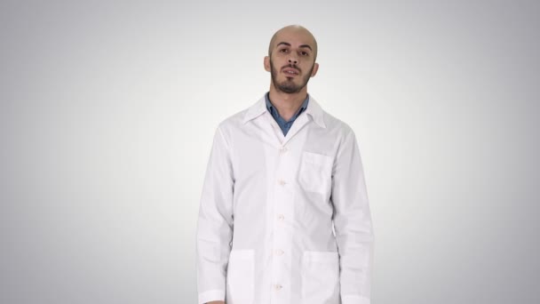 Arabo medico parlando con fotocamera su sfondo gradiente. — Video Stock