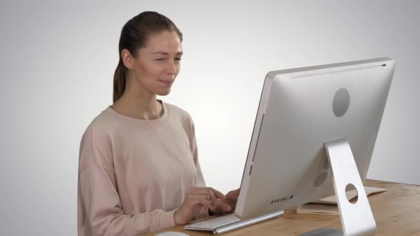 コンピュータを使用して、グラデーションの背景に微笑むアイデアを持っているブロンドの女性. — ストック動画