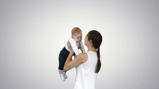 Junge Mutter spielt mit Baby, indem sie es aufrichtet, Alpha-Kanal — Stockvideo