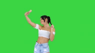 Yeşil Ekran 'da selfie çeken güzel genç bir kadın, Chroma Key.