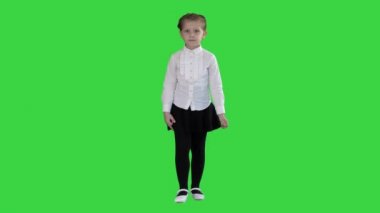 Küçük ciddi kız bir yeşil ekran üzerinde kamera doğru yürüyüş, Chroma anahtar.