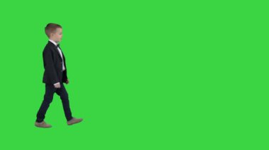 Klasik koyu mavi iş kostümü içinde bir yeşil ekran üzerinde yürüyüş çocuk, Chroma anahtar.