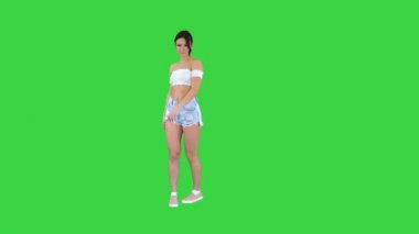 Yeşil Ekran 'da dans eden kot şortlu sevimli İspanyol kadın model, Chroma Key..