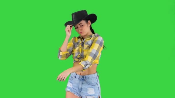 Ung dam i cowboyhatt dansar på en grön skärm, Chroma Key. — Stockvideo