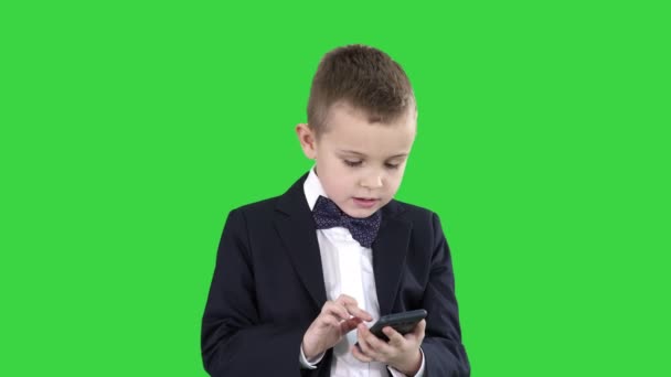 El muchacho inteligente está enviando mensajes de texto, jugando juegos en línea, enviando imágenes, descargando música, películas en una pantalla verde, Chroma Key . — Vídeos de Stock