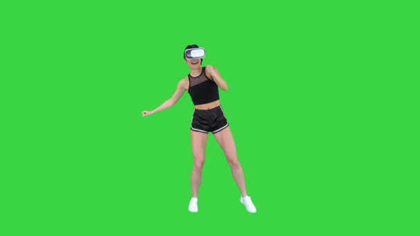 Щасливий посміхався молодої дівчини, використовуючи VR гарнітура окуляри грають танцюючої гри перший раз на зеленому екрані, ключ кольоровості. — стокове відео