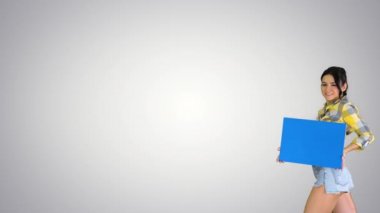 Degrade arka planda boş tahta tutan genç büyüleyici esmer model.